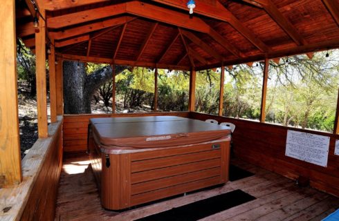 Large hot tub in an outdoor roofed building with open air sides